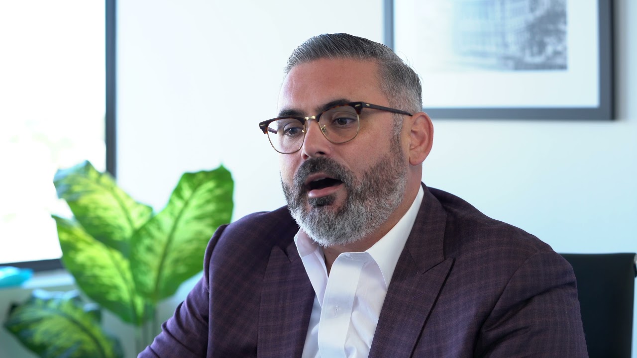 A white-bearded man with glasses candid shot while talking