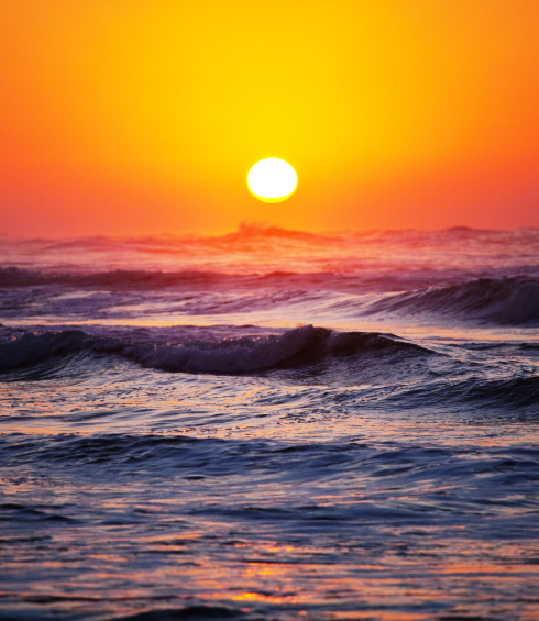 Image of an ocean kissing the sunset.